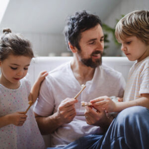 Vater putzt mit seinen Kindern zusammen die Zähne