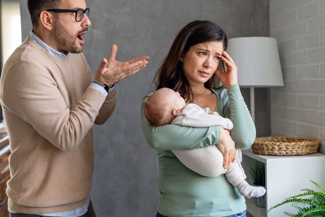 Eine überlastete Mutter hält ihr Kind auf dem Arm. Der Vater steht daneben. Das Problem: Das Kind bevorzugt nur die Mutter