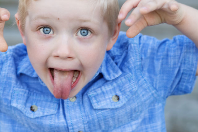 Kind streckt die Zunge raus.